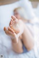 A woman laying on a bed with her feet up.