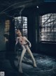 A woman sitting on a chair in an abandoned building.