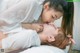 A man and a woman laying on top of a bed.