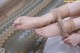 A woman is putting on a pair of barefoot sandals.