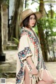 A woman in a straw hat is posing for a picture.