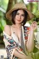 A woman in a straw hat is posing for a picture.