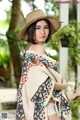 A woman wearing a straw hat and a colorful shawl.