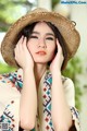 A woman wearing a straw hat is posing for a picture.