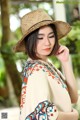 A woman wearing a straw hat poses for a picture.