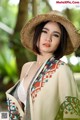 A woman wearing a straw hat and a colorful shawl.