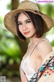 A woman wearing a straw hat posing for a picture.