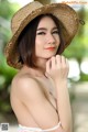 A woman wearing a straw hat posing for a picture.