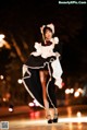 A woman dressed in a maid outfit is walking down the street.