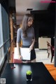 A woman standing in front of a table holding a laptop computer.