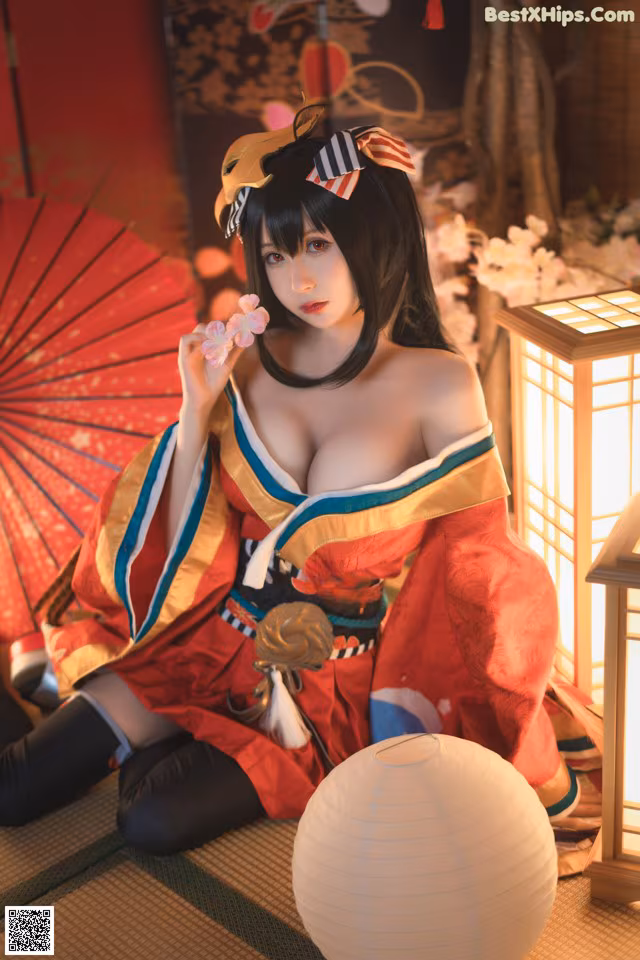 A woman in a red and blue kimono sitting on the floor.