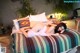 A woman laying on top of a bed covered in pillows.