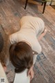 A woman bending over on a yoga mat in a living room.