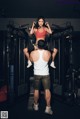 A man and a woman in a gym doing exercises.