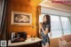 A woman standing in a hotel room holding a cup of coffee.