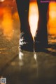 A person standing in the rain with their feet in the water.