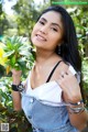 A woman holding a yellow flower in her hand.