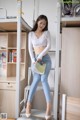 A woman sitting on top of a bunk bed holding a book.