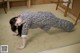 A woman in a black and white dress is doing a handstand.