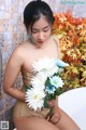 A woman sitting in a bathtub holding a bunch of flowers.