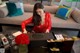 A woman in a red dress sitting at a table.